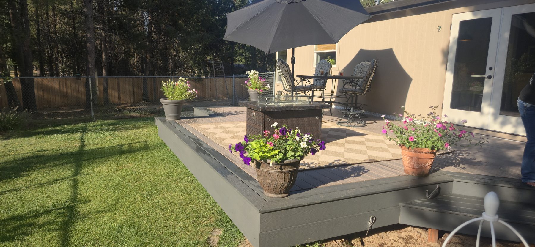 Finished composite deck with furniture, umbrella, and potted flowers, La Pine, Oregon