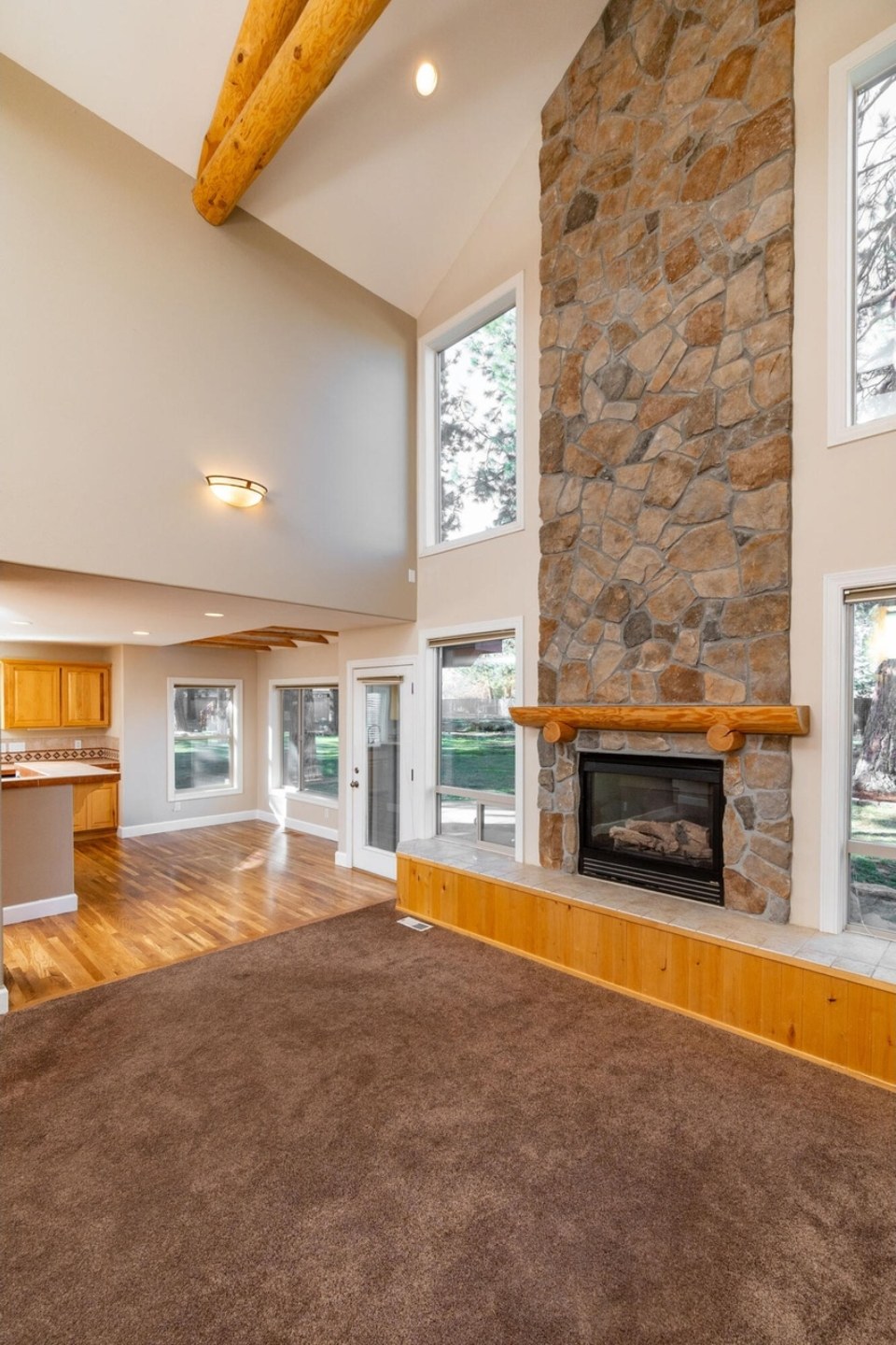 Two-story great room with stone fireplace and timber trusses, Zircon, Central Oregon